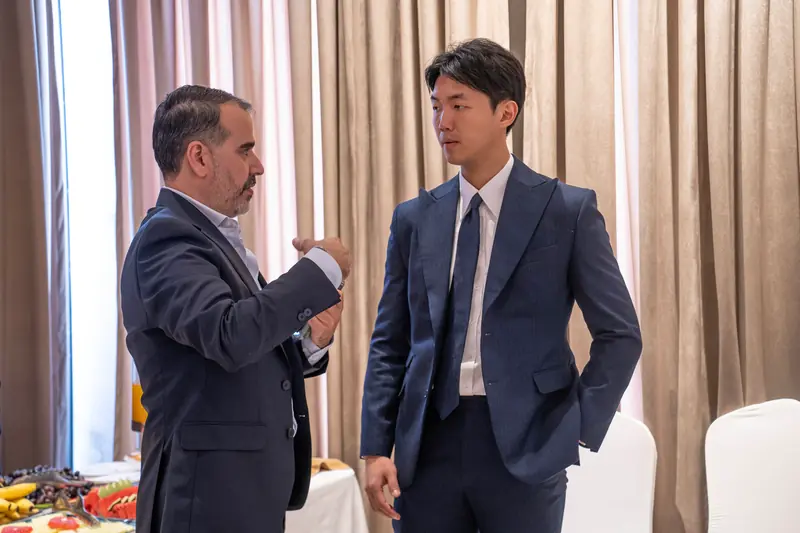 Two men in suits talking during a break in the conference hall
