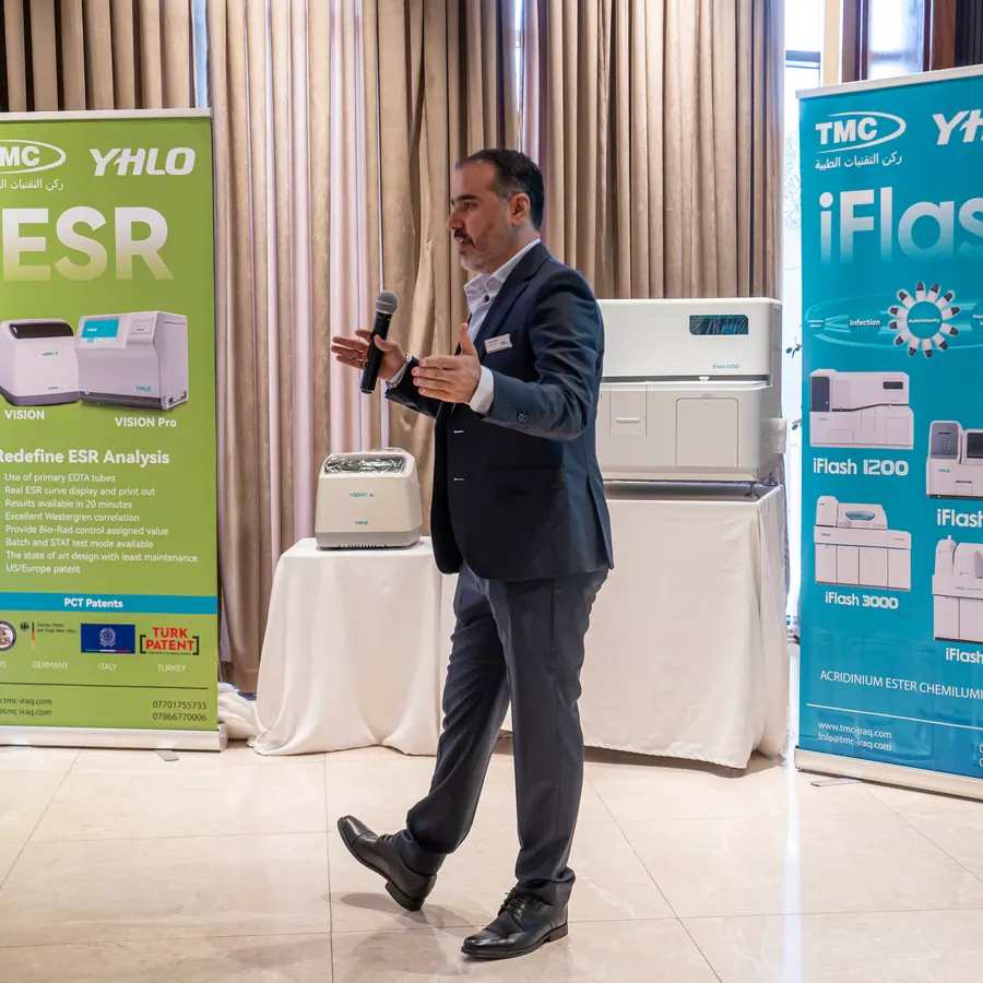 A TMC presenter between the ESR and iFlash displays at the TMC × YHLO scientific day, Baghdad, May 2025